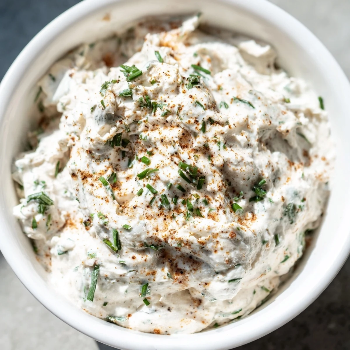 Spoon-dipped view of the Creamy Dip Bowl, highlighting its smooth texture next to crunchy pita chips.
