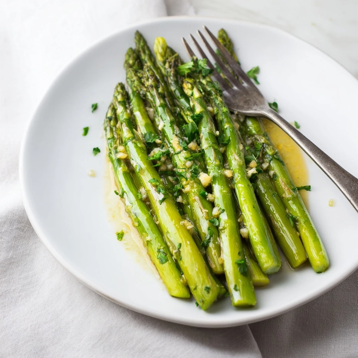 Sautéed Lemon Garlic Asparagus with butter glistens in a skillet, tender spears coated in garlic and bright lemon zest, ready to serve as a vibrant side.