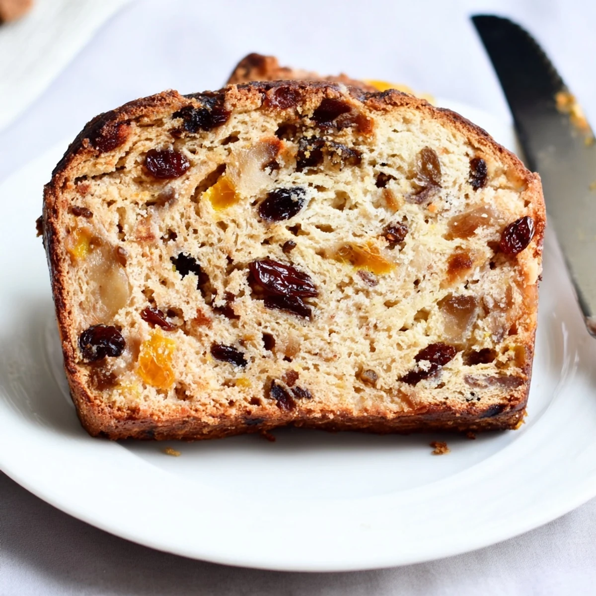 Homemade Irish Barmbrack fruit bread loaf resting on a wooden board, perfect for buttering and serving with afternoon tea.