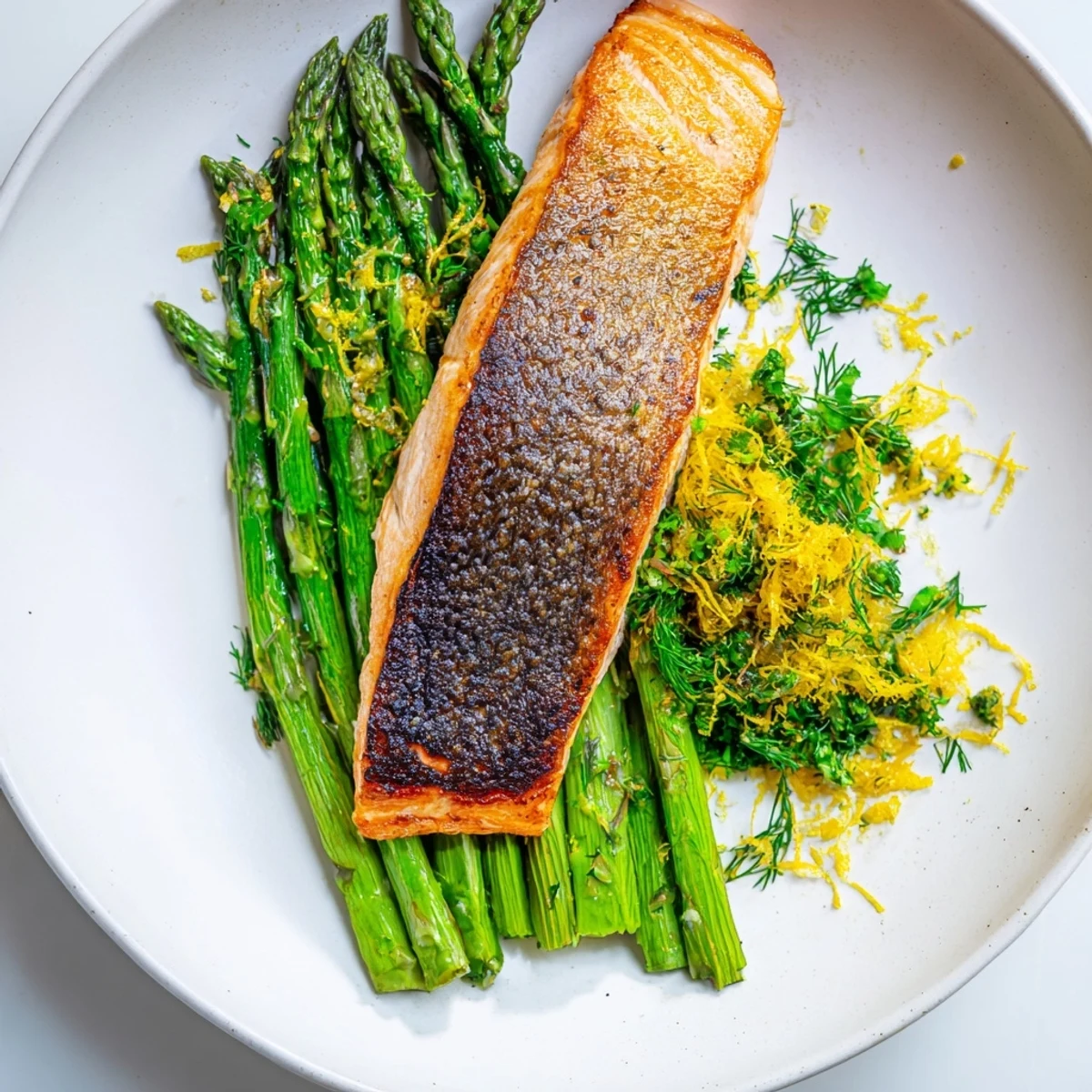 Sizzling Pan Seared Salmon with Asparagus Spears in a skillet, showcasing crispy skin and bright green tender spears.
