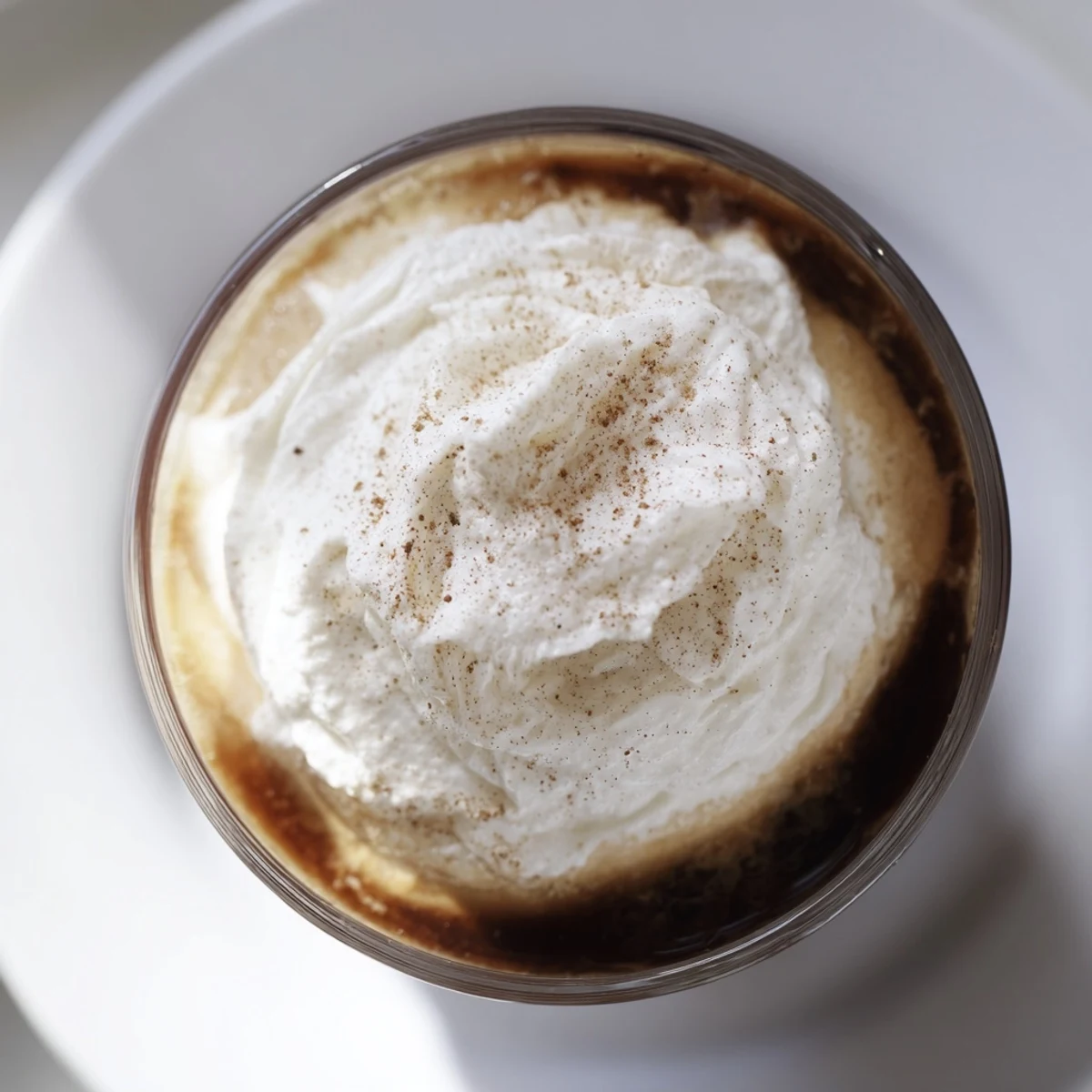 Two elegant glasses of Irish Coffee Mocktail with Whipped Cream garnished with nutmeg, ready for a cozy, alcohol-free treat.