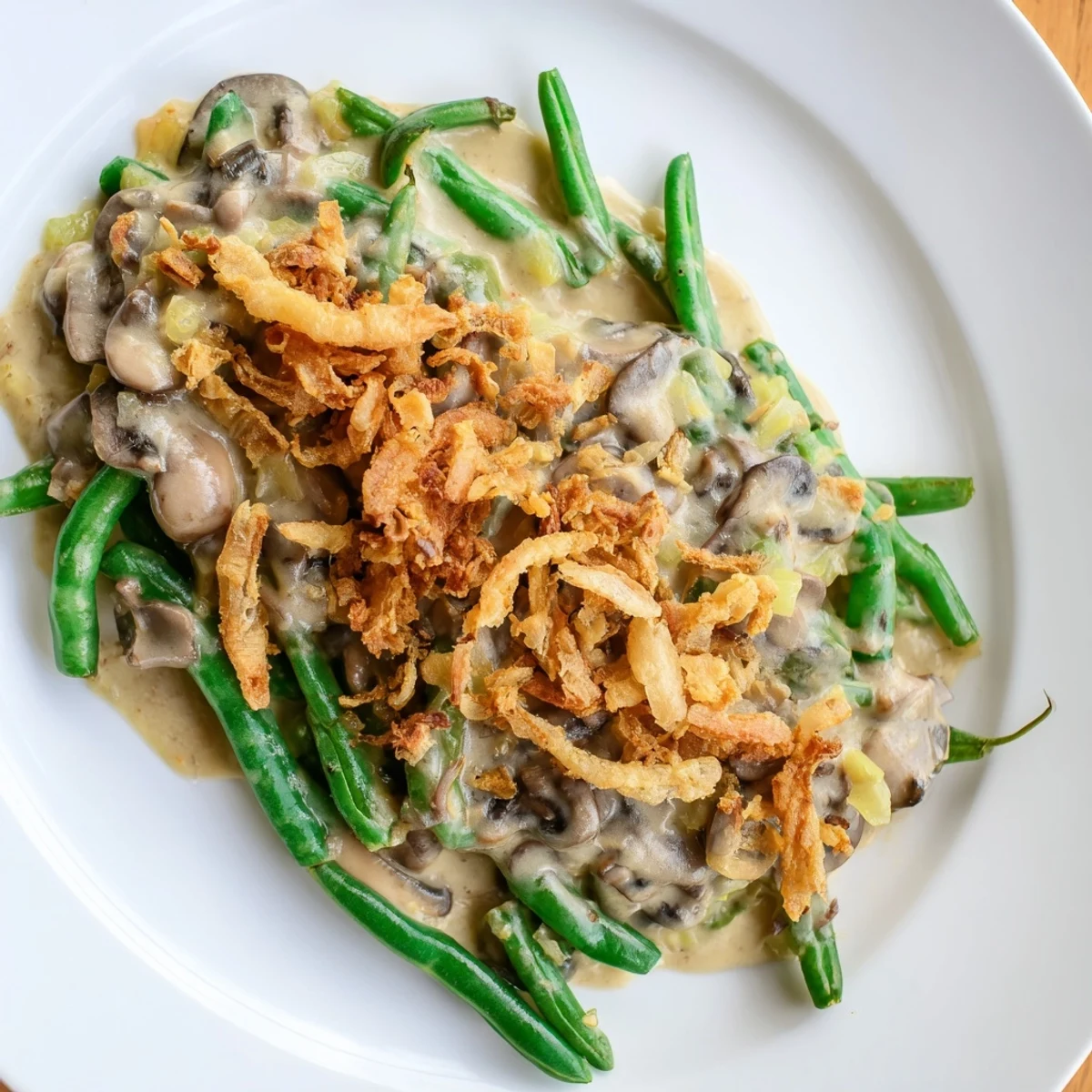 A close-up view of a bubbling hot Green Bean Casserole with Crispy Onions, serving as a perfect side dish for a holiday meal on a rustic table.