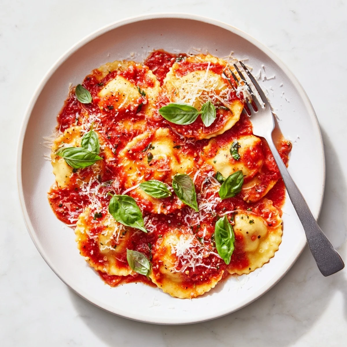 Tender 20-Minute Ravioli with Simple Sauce bathed in a rich, chunky tomato-basil sauce on a white plate.