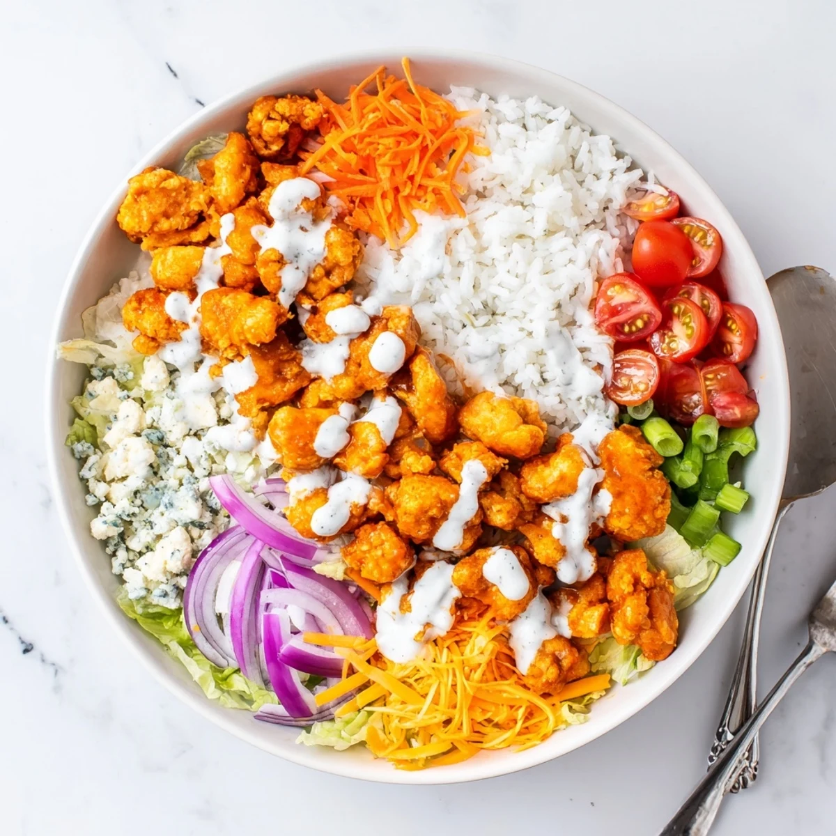 Up close view of Buffalo Chicken Bowls with shredded carrots, cherry tomatoes, and crumbled blue cheese, ideal for a gluten free lunch.