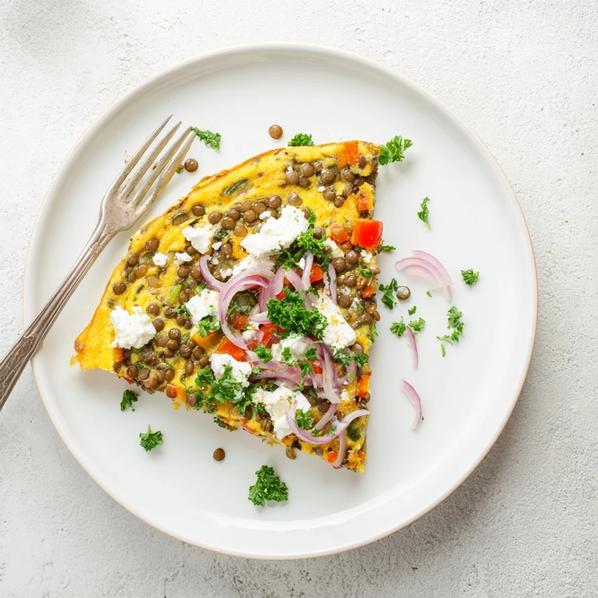 A golden Healthy Lentil and Feta Frittata served warm with fresh parsley garnish and a side green salad.
