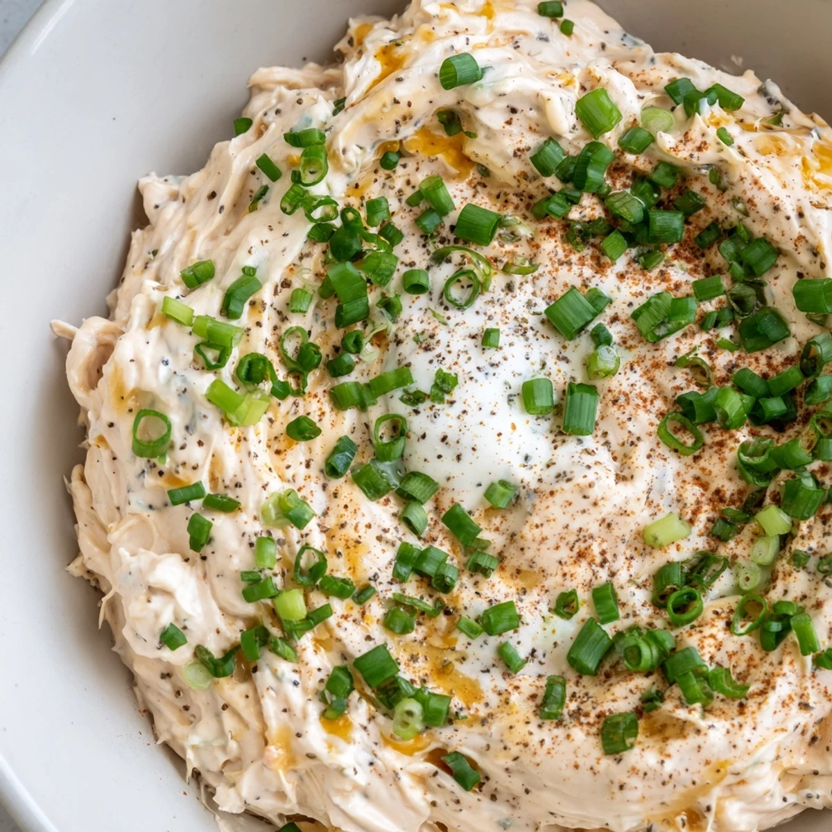 Creamy savory pretzel dip topped with fresh chives served alongside warm soft pretzels