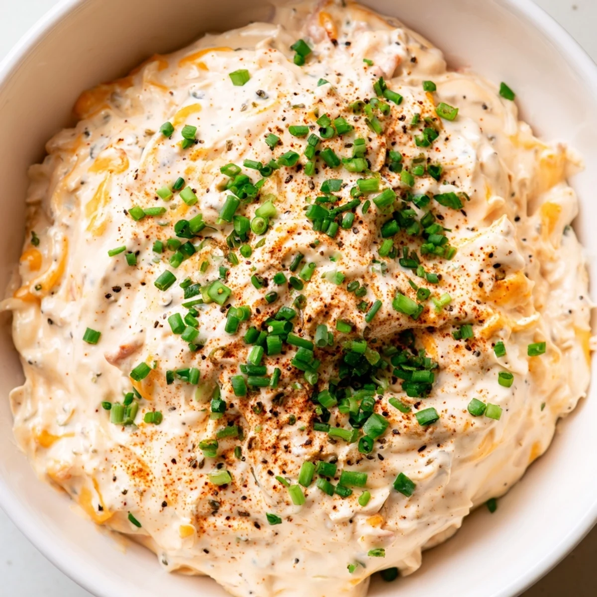 Rich and tangy savory pretzel dip in a bowl with pretzels for dipping