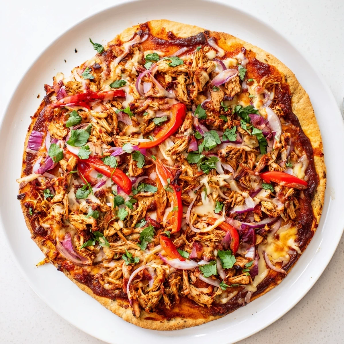 Delicious homemade BBQ chicken pizza drizzled with extra sauce and sprinkled with cilantro