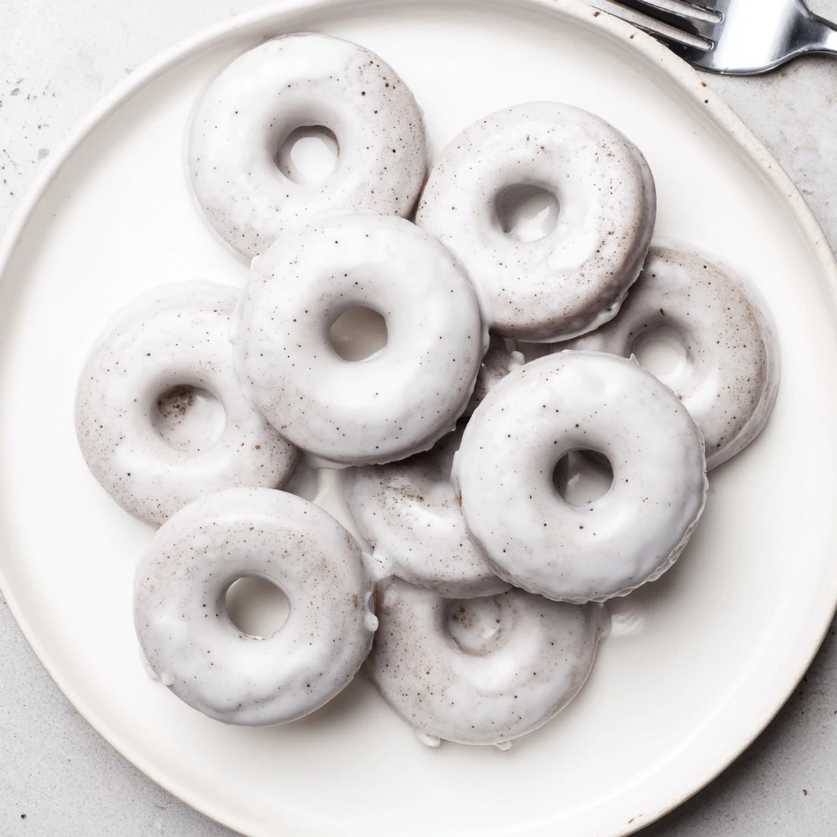 Golden brown Earl Grey mochi donuts topped with sweet white glaze on wire rack