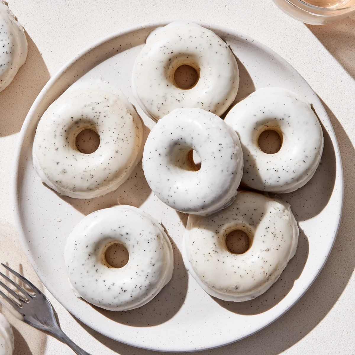 Chewy tea-infused donuts arranged on white plate with dotted glaze dripping down sides