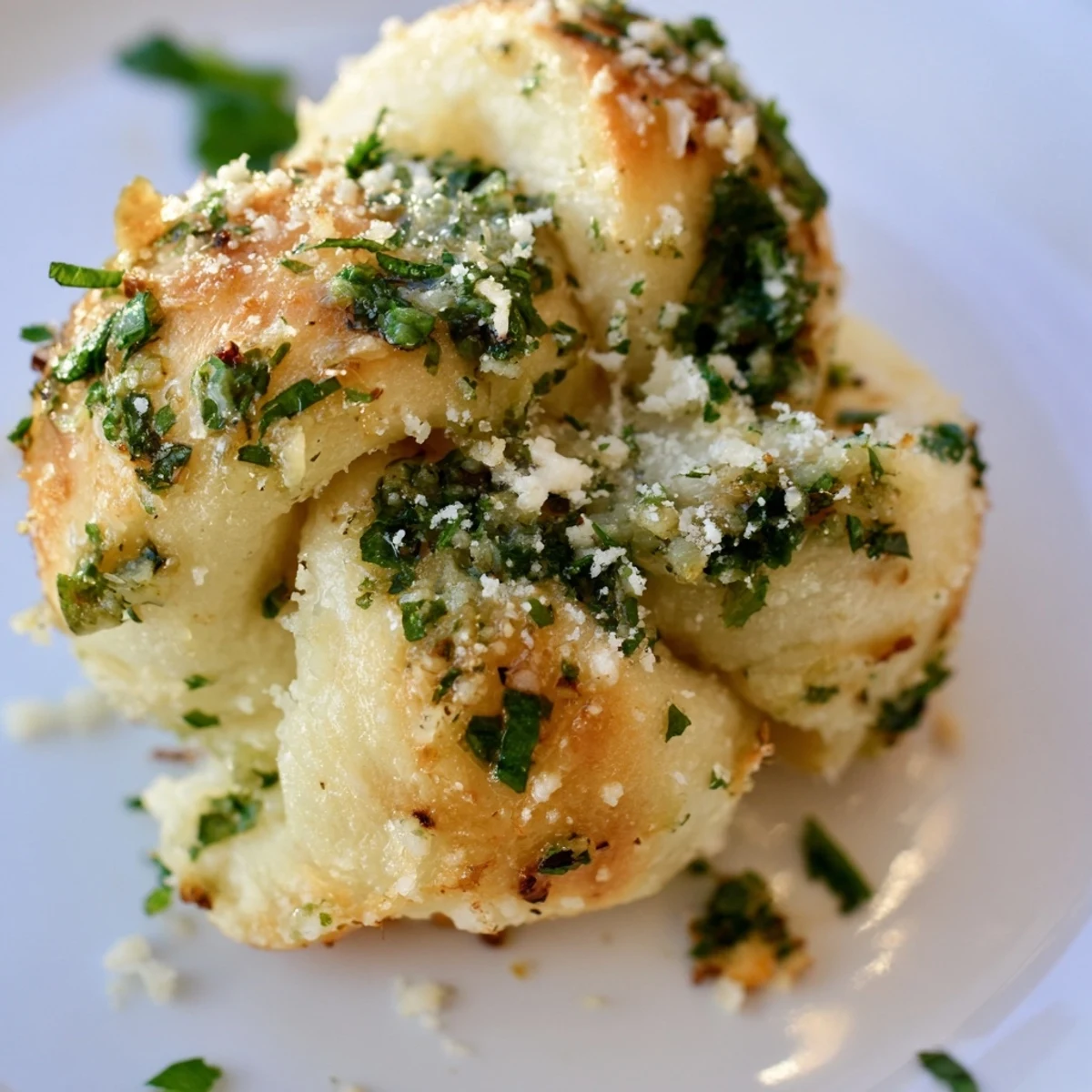 Warm gluten-free garlic knots drizzled with garlic butter, ready for dipping into marinara sauce