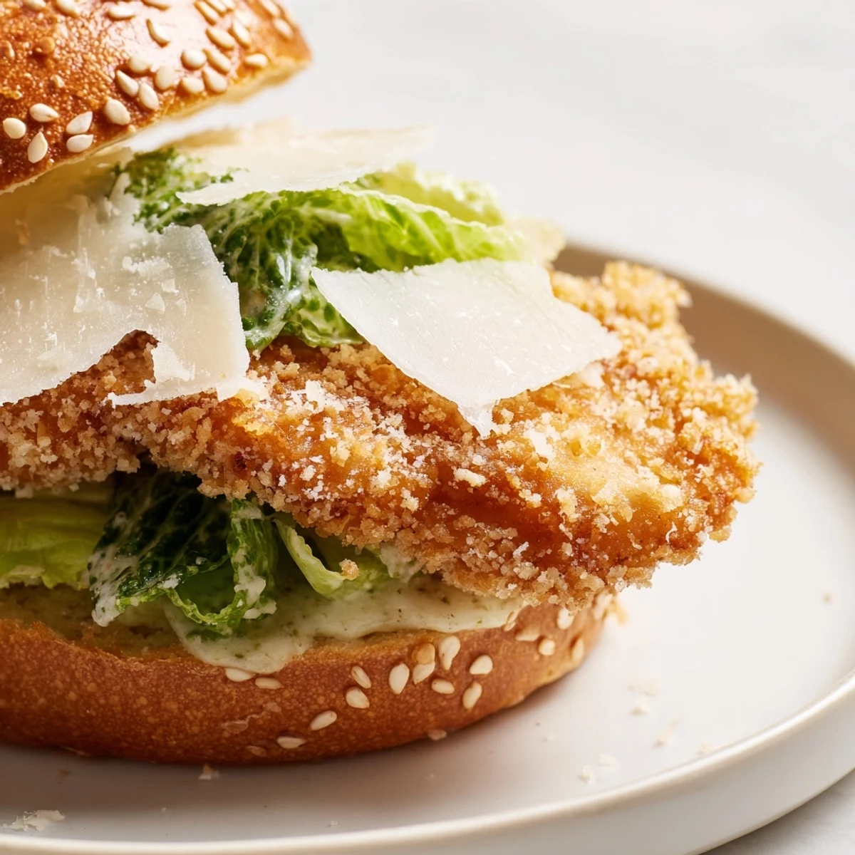 Golden brown crispy chicken breast stacked on toasted brioche bun with fresh romaine lettuce