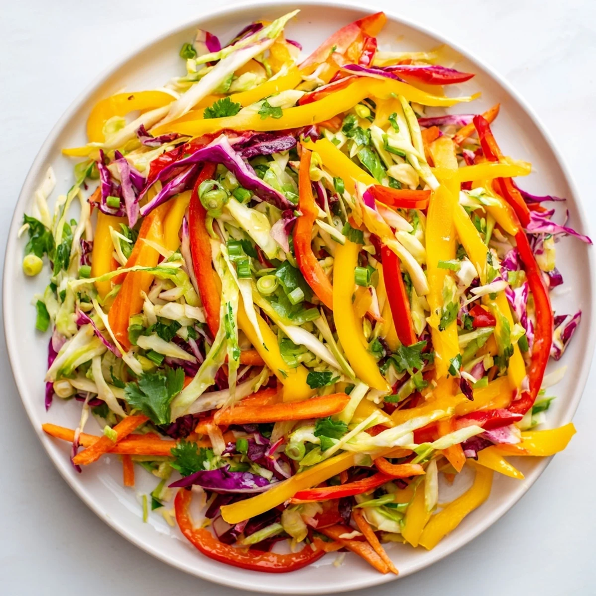 Colorful mango slaw with shredded cabbage, crisp vegetables, and zesty lime dressing in a white bowl