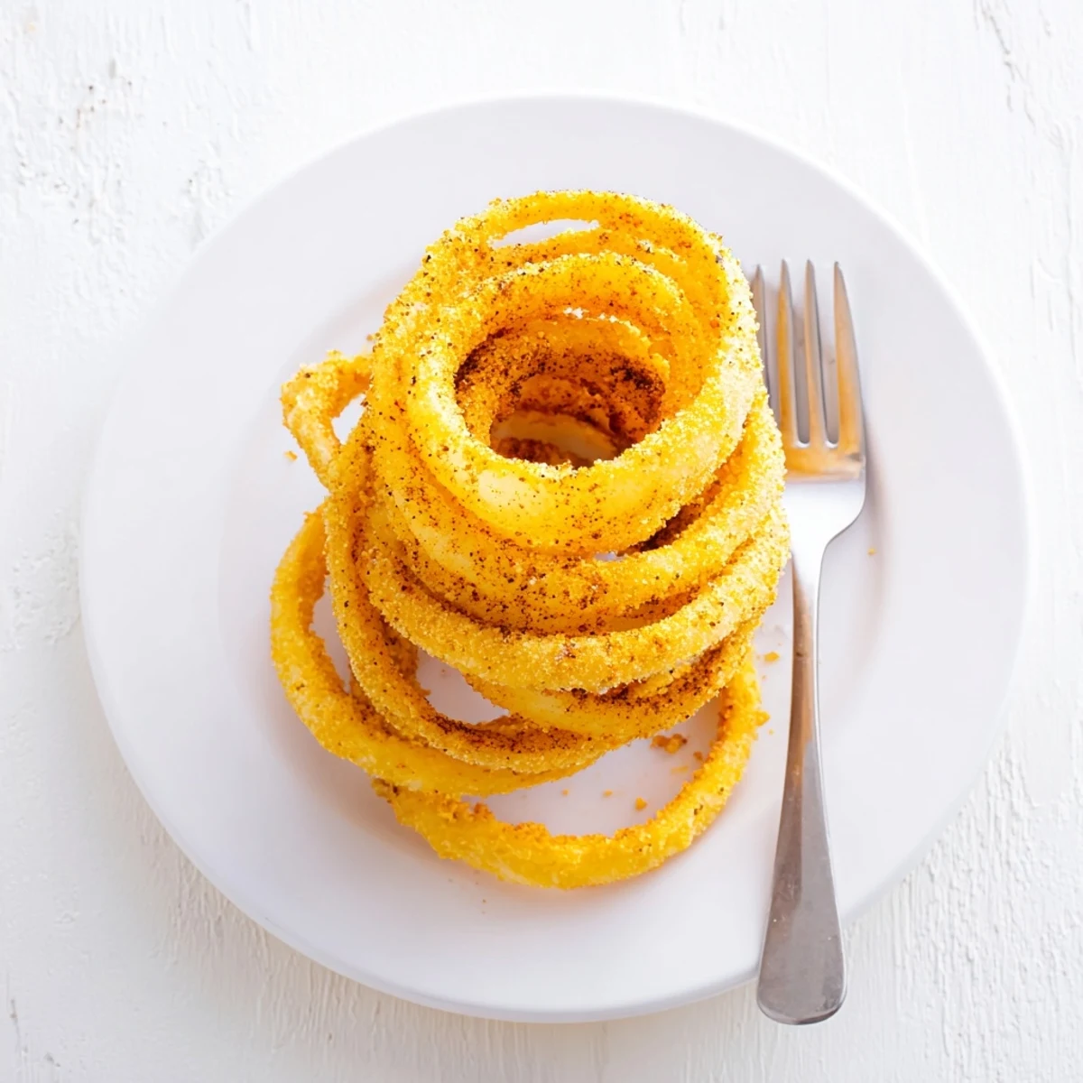 Ultra-thin fried onion rings with a light batter coating served as crunchy appetizers