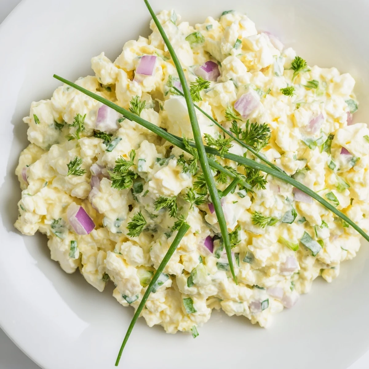 Light and fluffy cottage cheese egg salad featuring diced red vegetables and green herbs