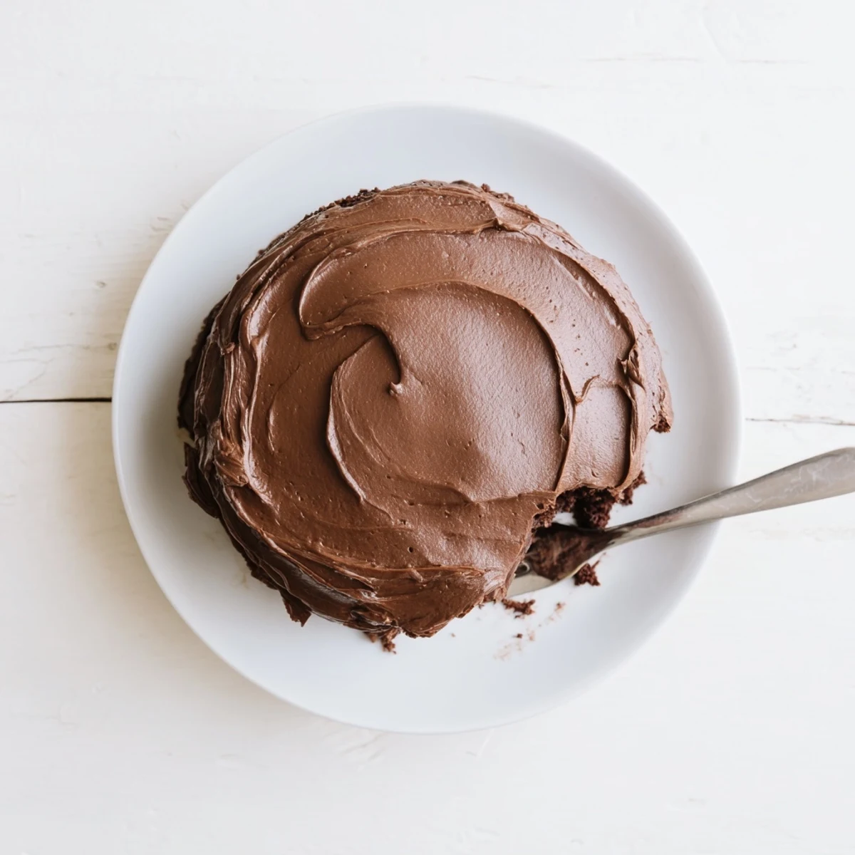 Moist chocolate cake slices topped with whipped buttercream frosting and fresh raspberries