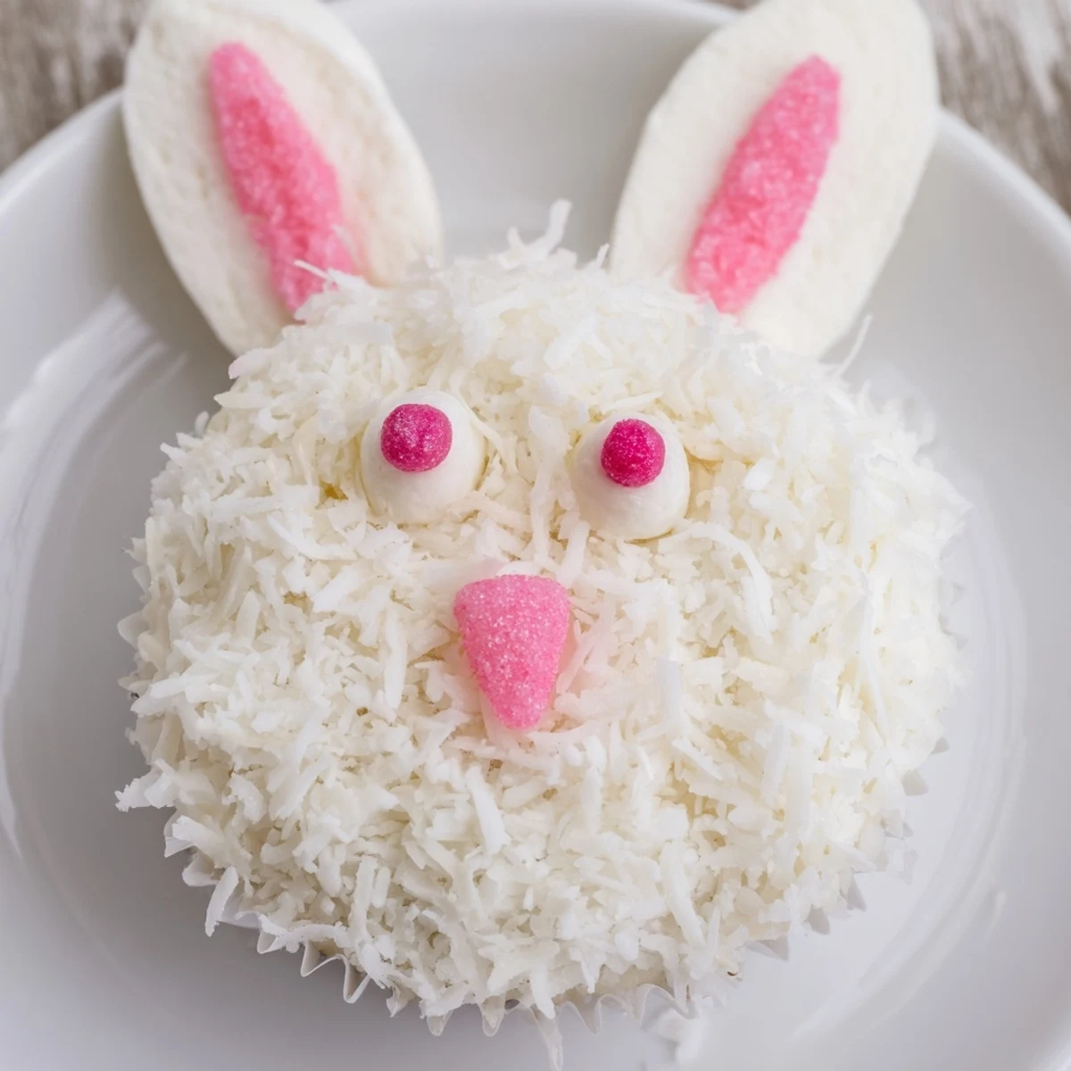 Spring dessert featuring bunny cupcakes with buttercream frosting dipped in sweetened coconut