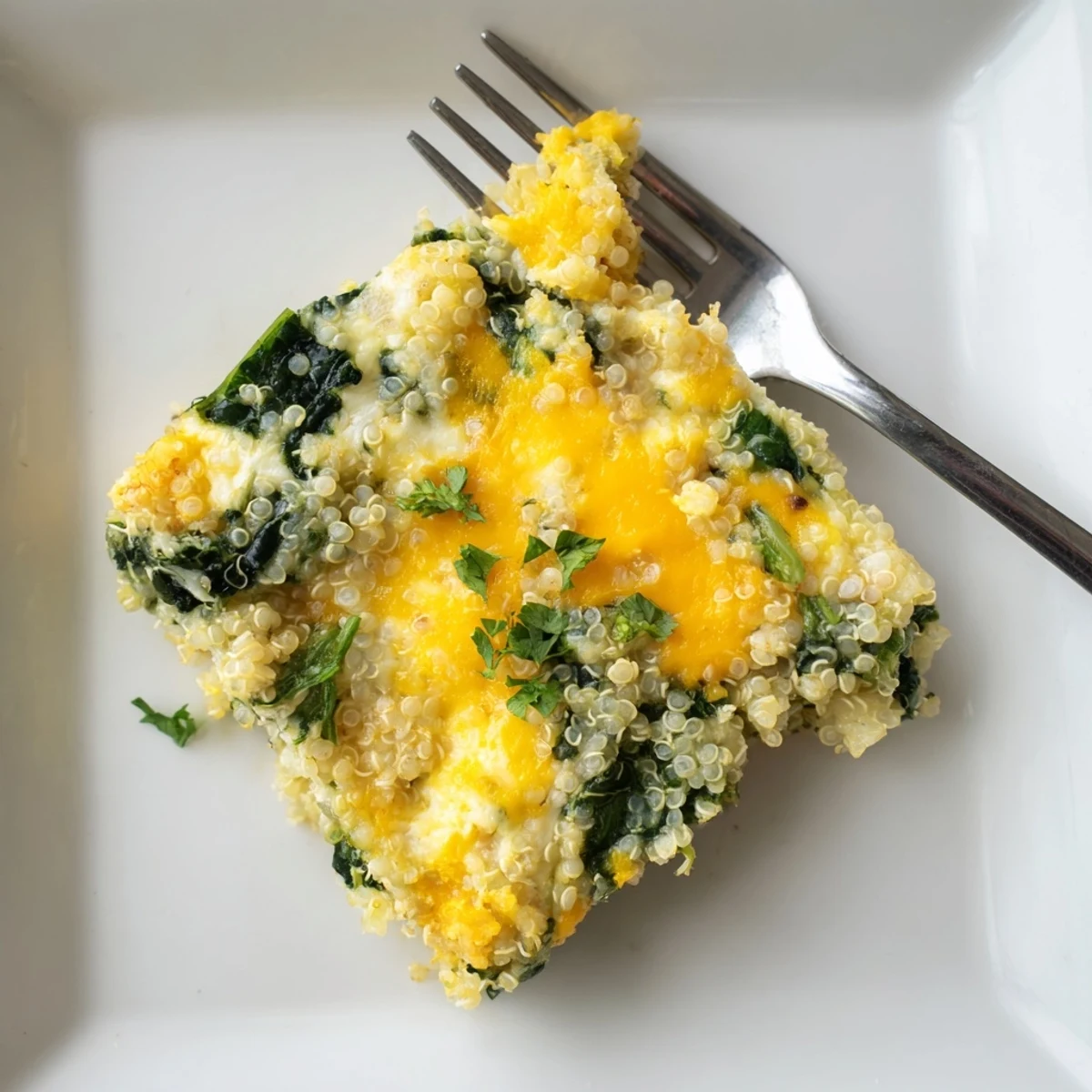 Protein-packed vegetarian casserole featuring fluffy quinoa, wilted spinach, and baked eggs in a serving dish