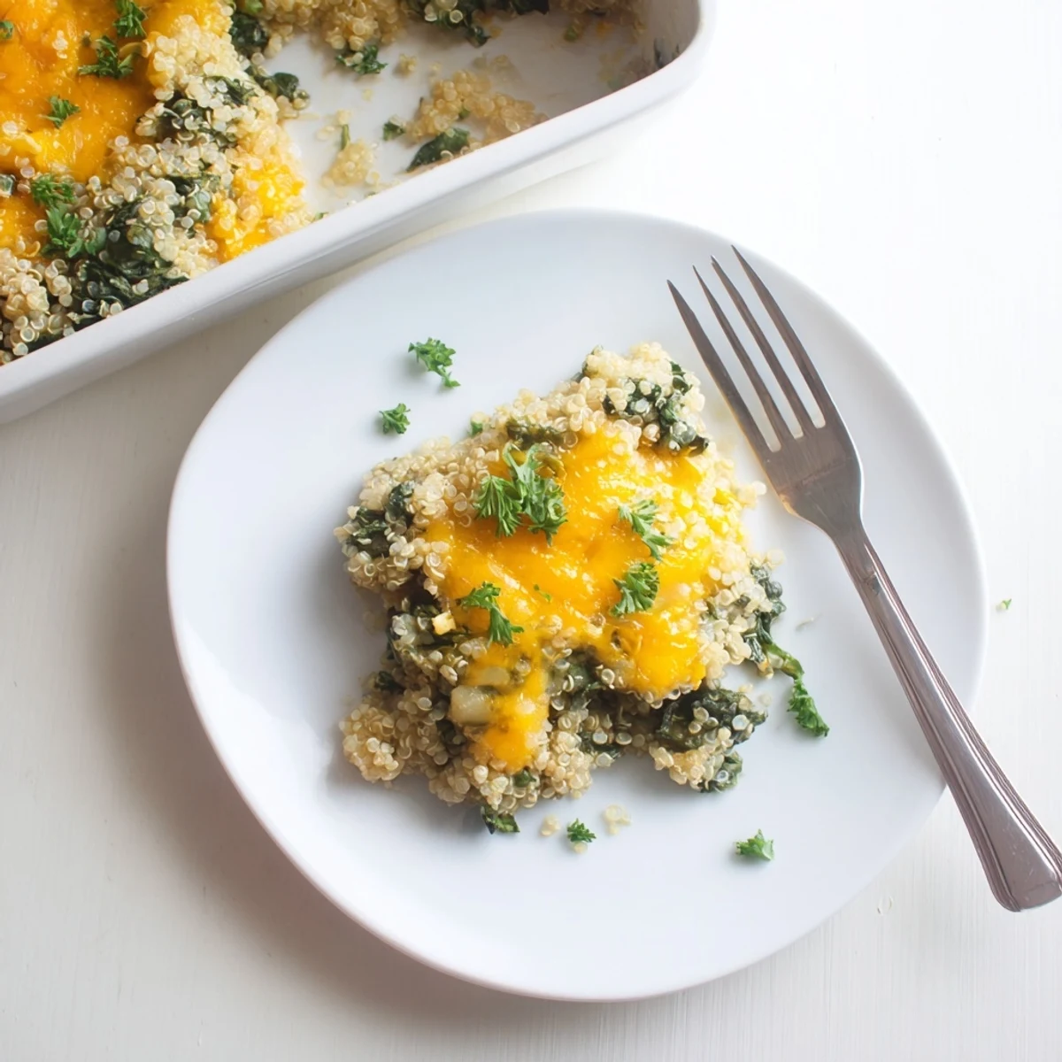Golden quinoa spinach and egg bake with melted cheese topping and fresh parsley garnish
