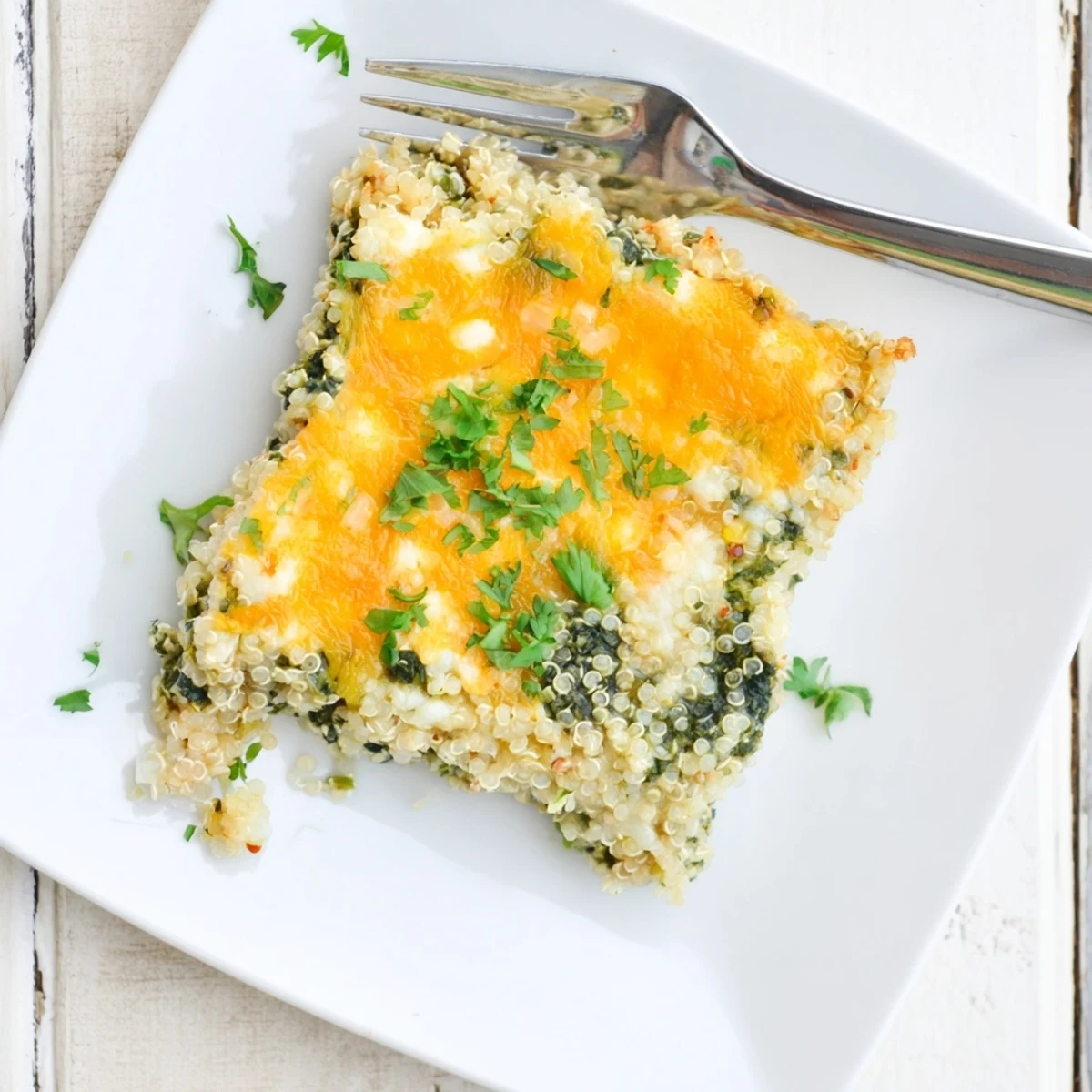 Wholesome breakfast bake showcasing tender spinach, fluffy quinoa, and cheesy golden crust in square pan
