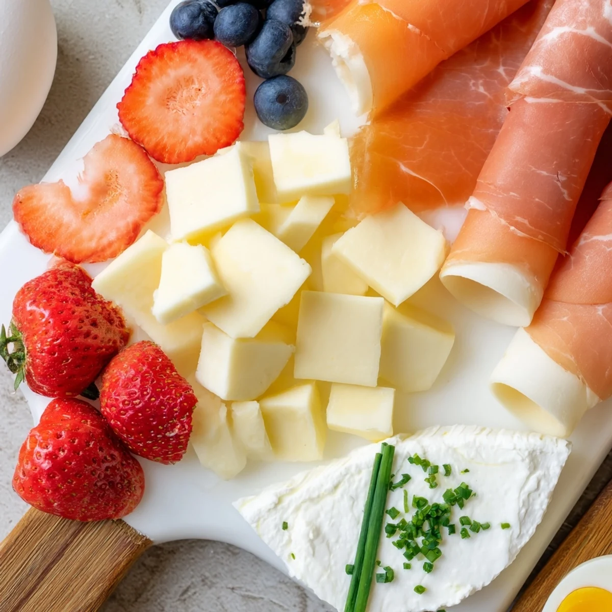 Generous breakfast charcuterie board featuring smoked salmon, bagels, fresh fruit, and boiled eggs for brunch.