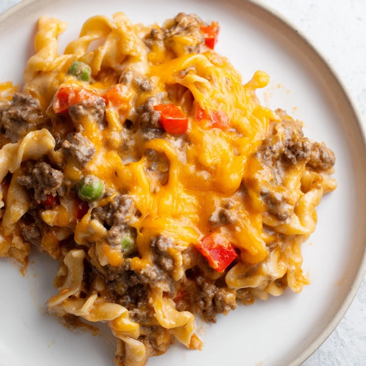 Golden bubbly cheesy beef and noodle casserole fresh from the oven with melted cheddar topping
