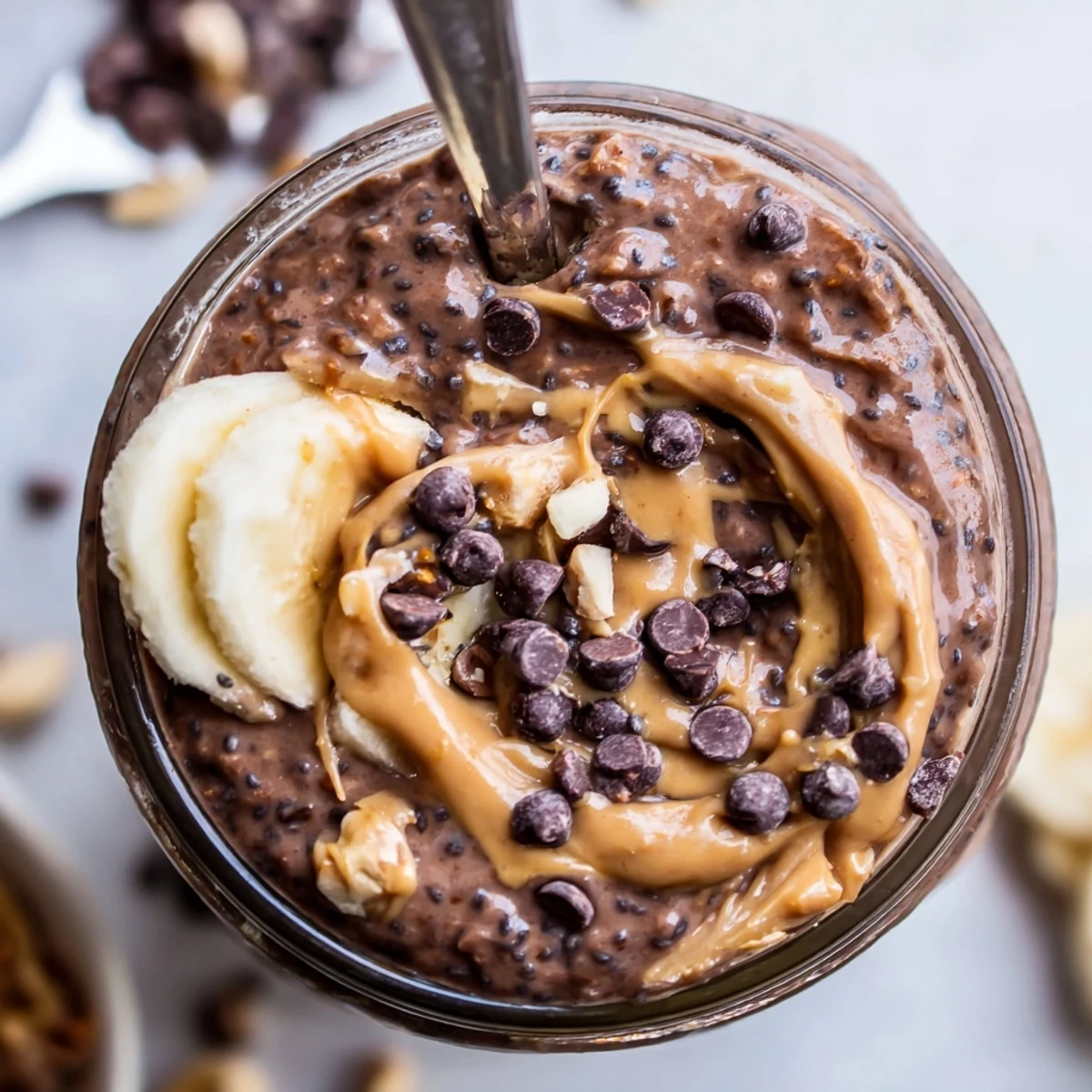 Creamy chocolate peanut butter overnight oats topped with chocolate chips in a mason jar