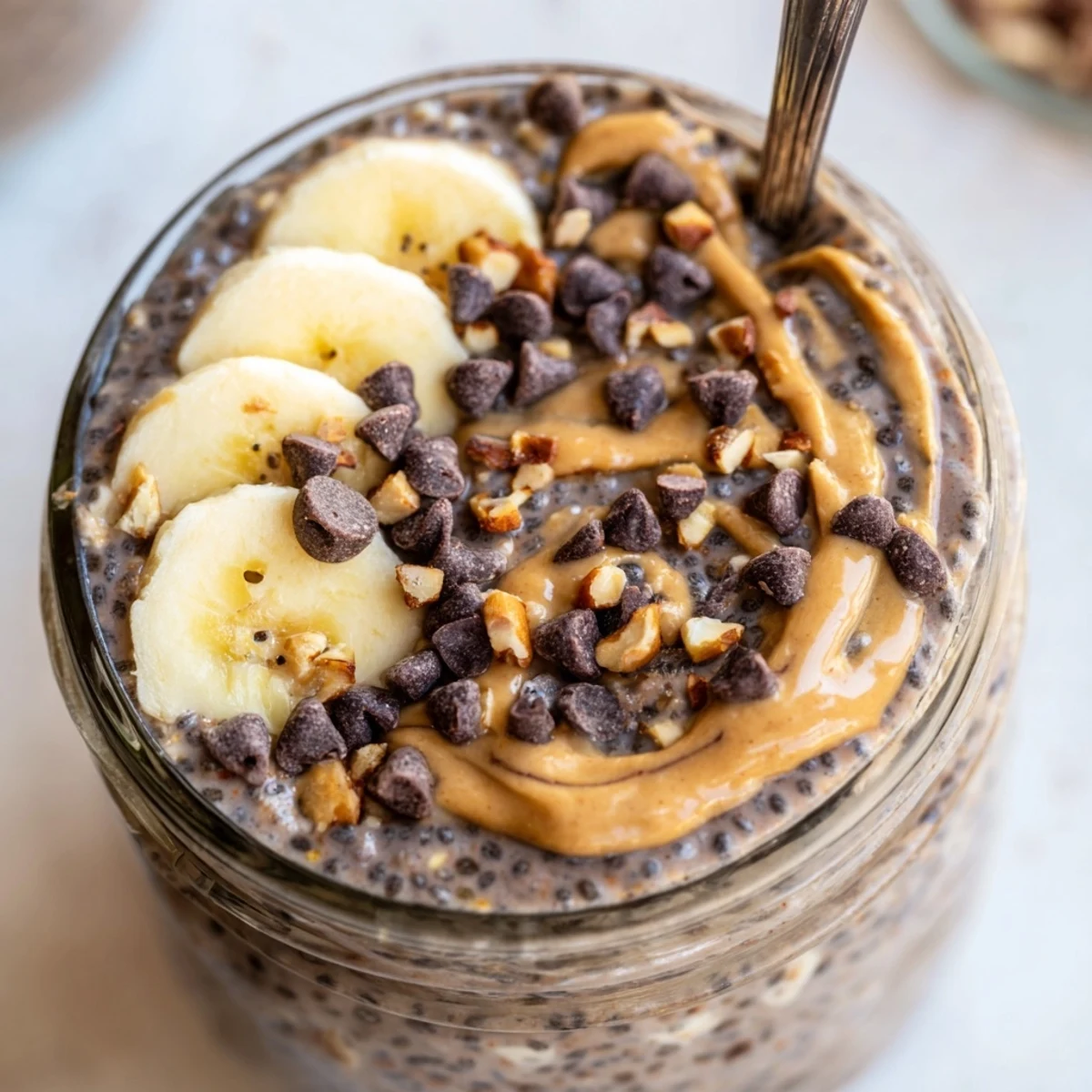 Thick chocolate peanut butter overnight oats served cold with chopped peanuts and banana slices