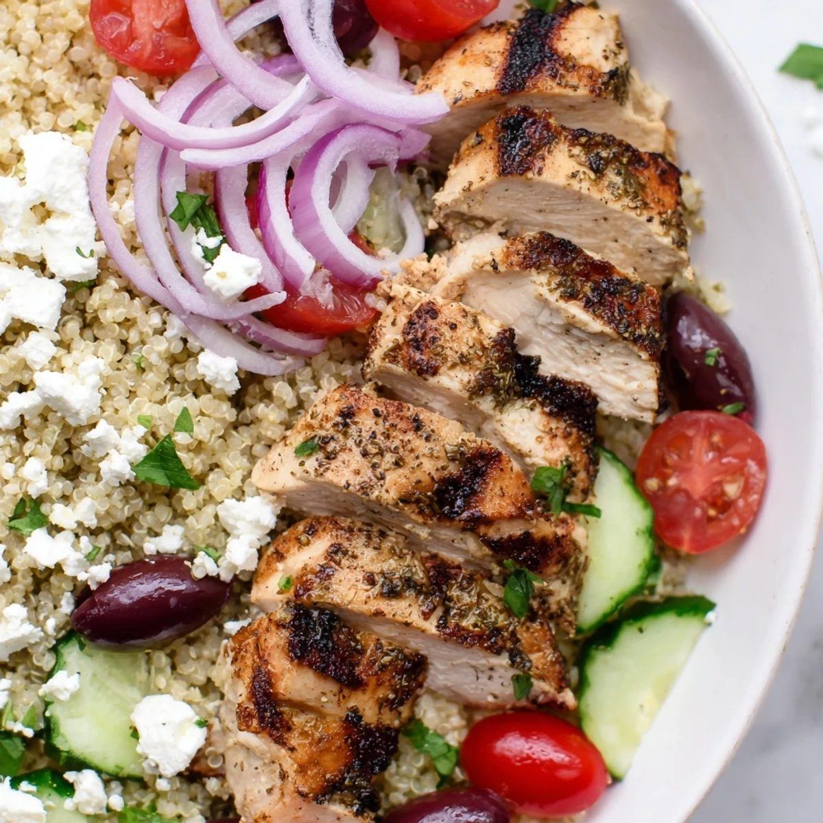 Fluffy quinoa and sliced chicken in a colorful Mediterranean Chicken Quinoa Bowl