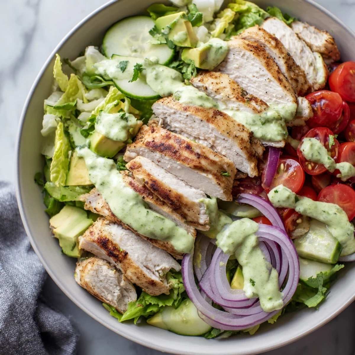 Protein-packed grilled chicken salad featuring ripe avocado chunks, mixed greens, and tangy lime dressing