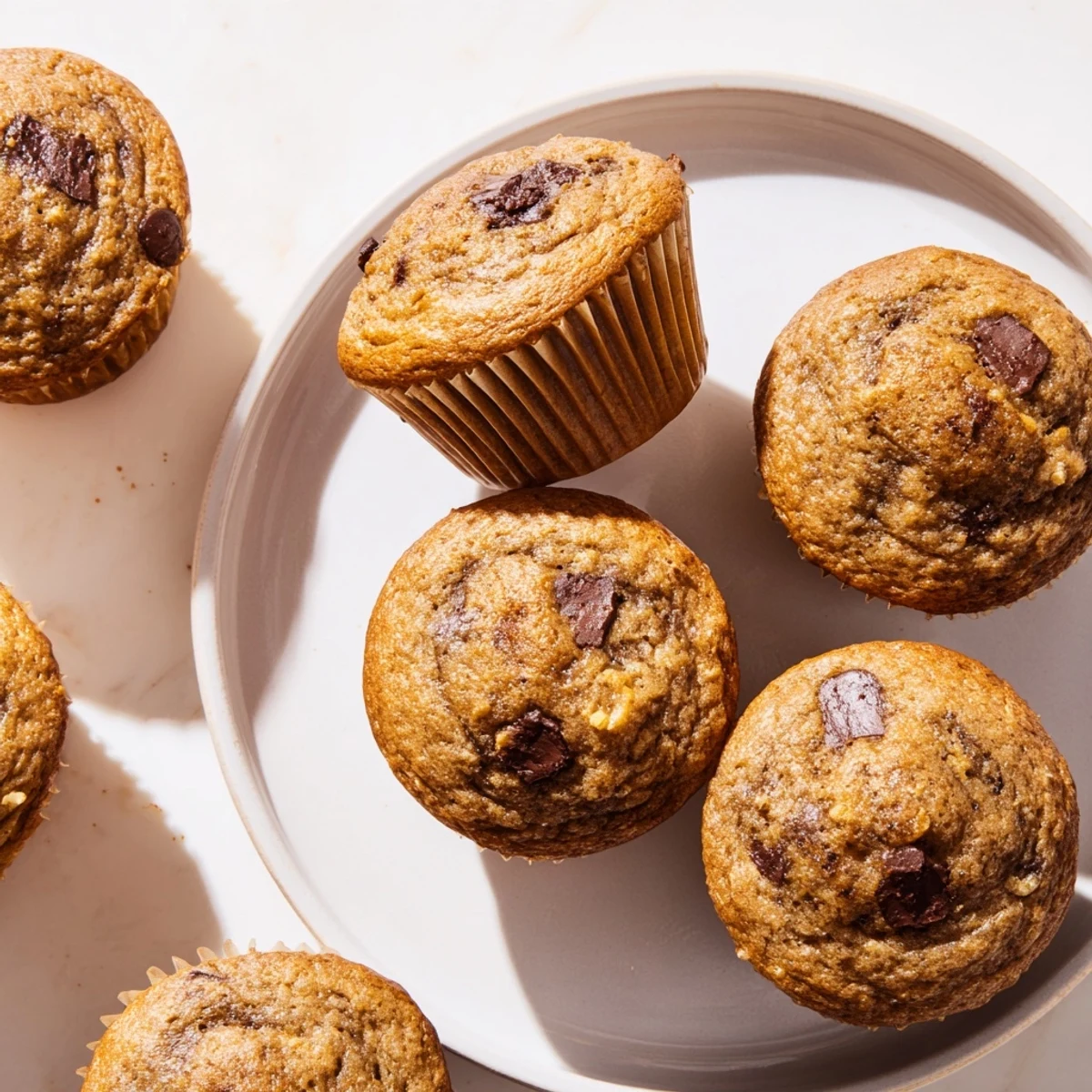 Moist American-style banana muffins split open revealing tender crumb and creamy peanut butter pockets