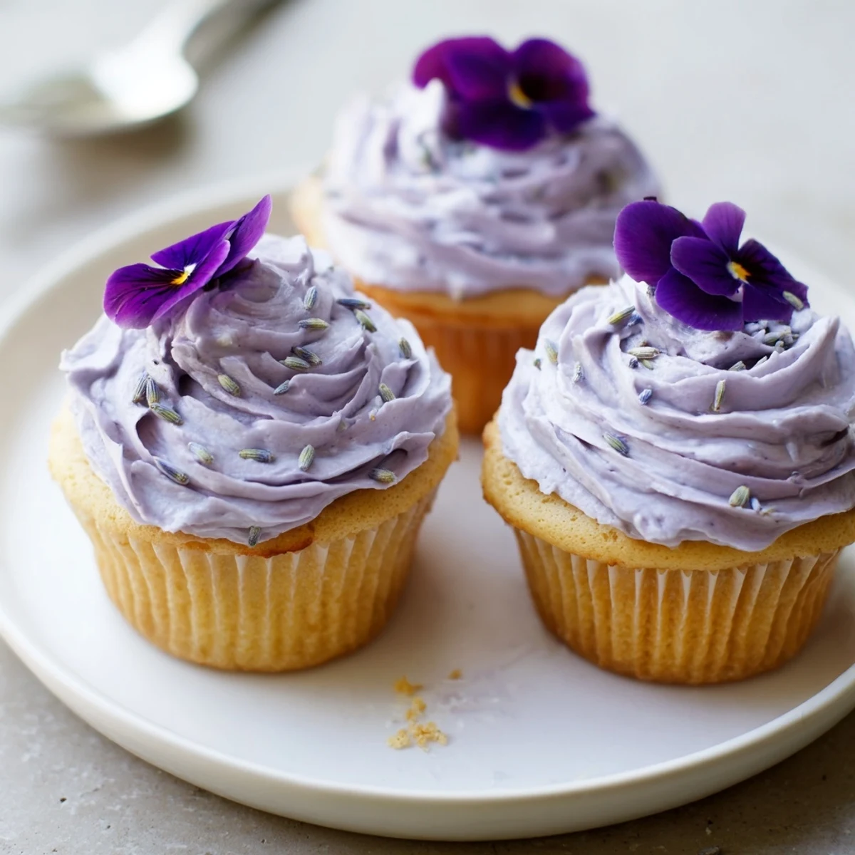 Lavender Buttercream Floral Frosting piped on vanilla cupcakes, light purple hue.
