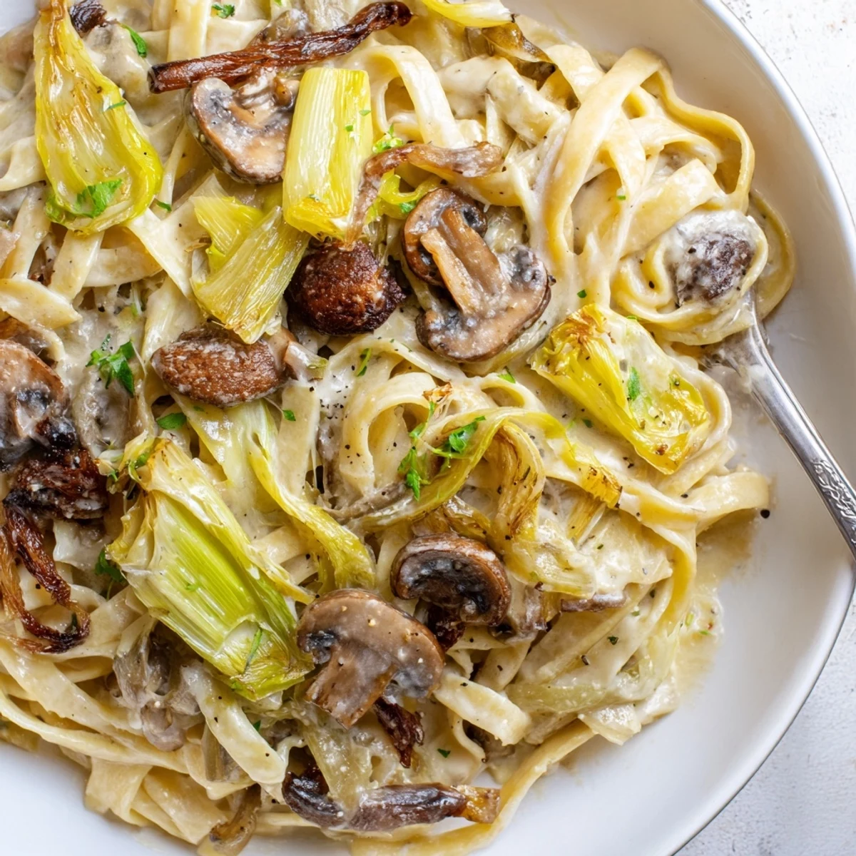 A bowl of silky noodles: Caramelized Leek Mushroom Gruyere Pasta ready to serve