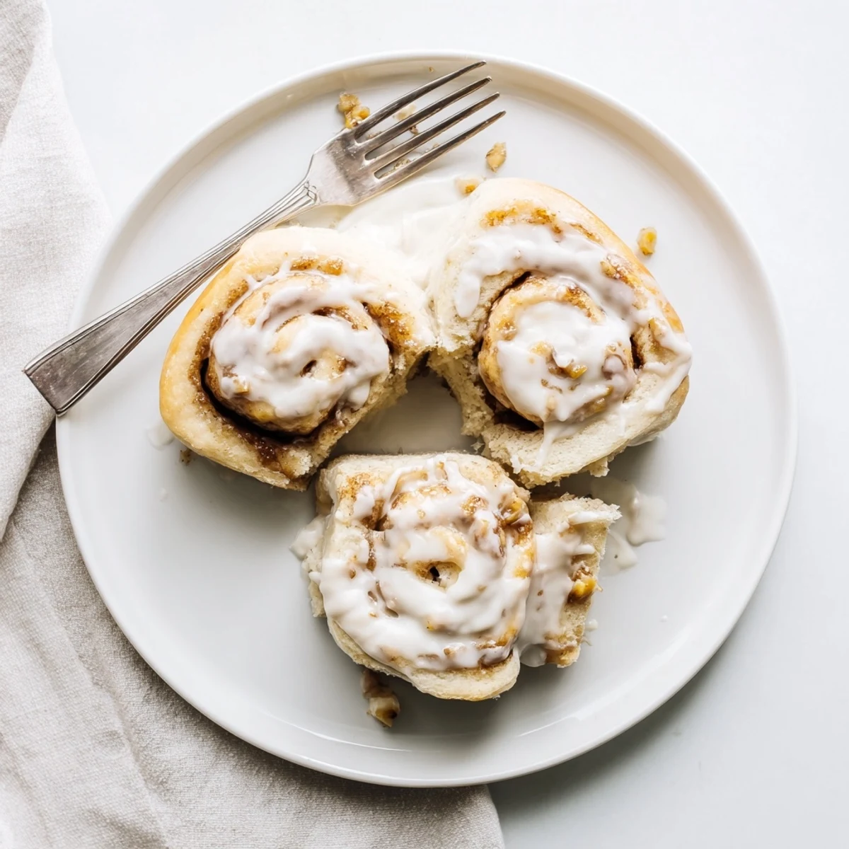 Warm Banana Bread Cinnamon Rolls drizzled with cream cheese icing, steaming
