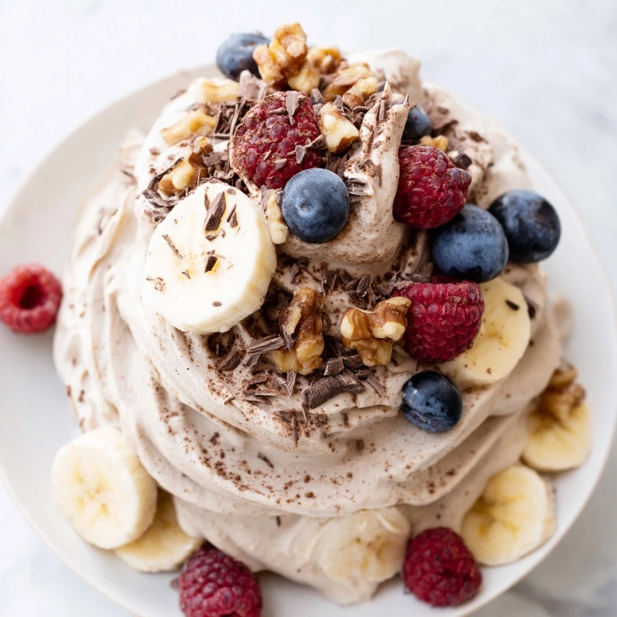 Creamy healthy nice cream recipe served in a bowl with fresh berry toppings and dark chocolate shavings