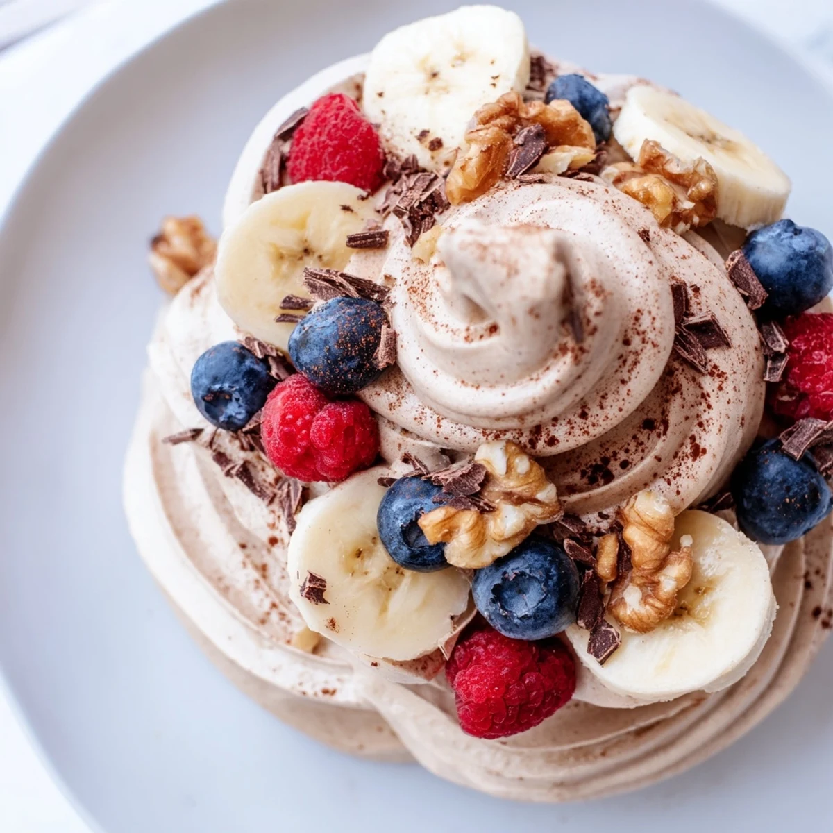 Silky smooth banana nice cream recipe swirled with peanut butter and topped with chopped nuts for crunch