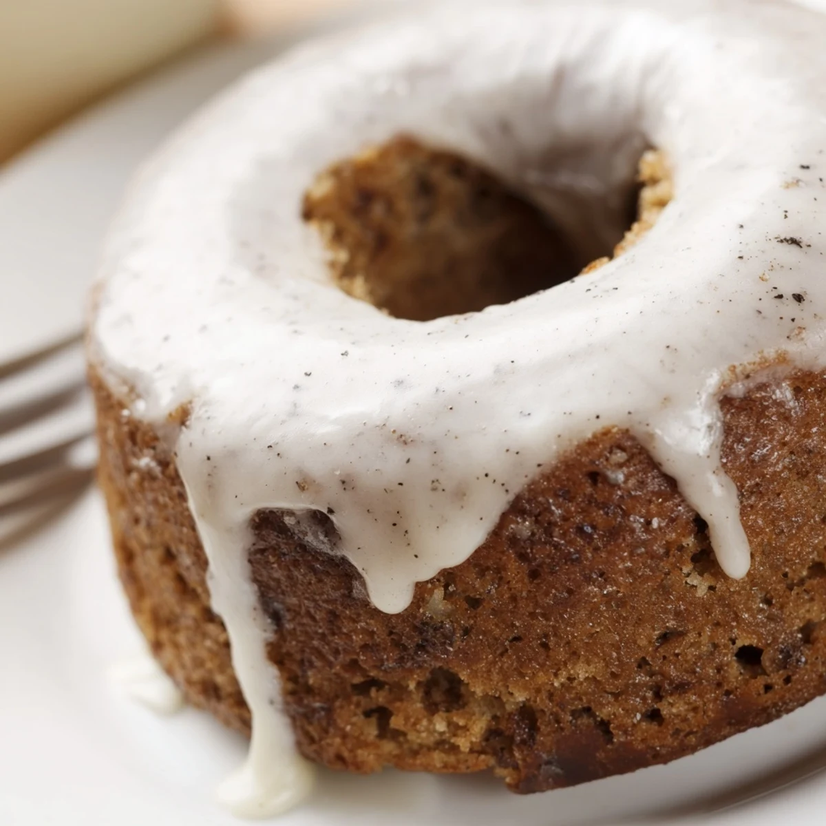 Golden banana bread donuts topped with sweet vanilla glaze on a wire rack