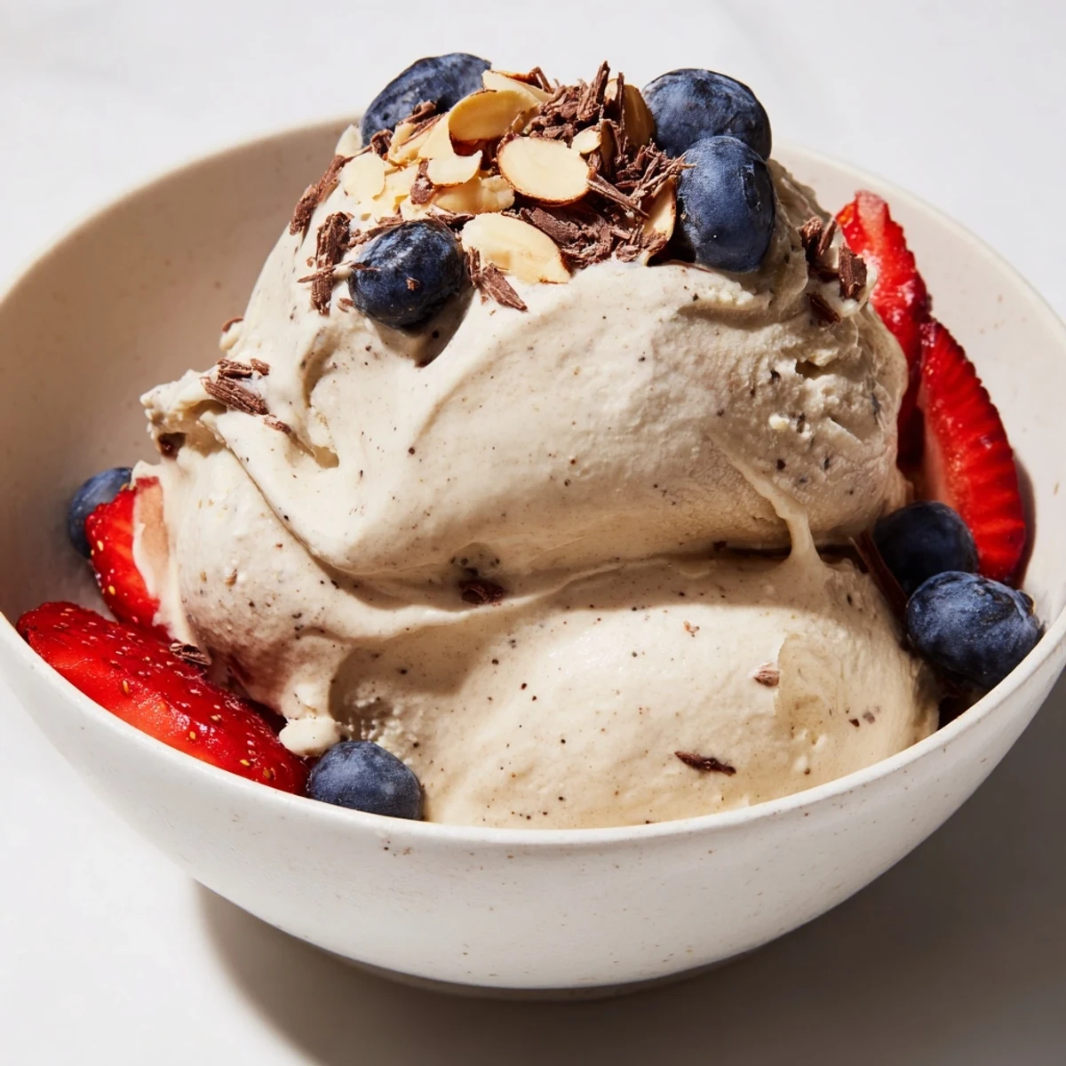 Vegan banana nice cream swirl topped with toasted coconut flakes and caramel sauce drizzle