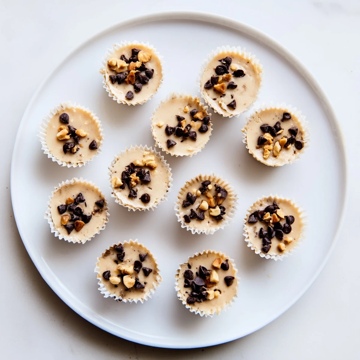 Close-up of high protein frozen peanut butter Greek yogurt bites with smooth texture and chocolate chip garnish on white plate