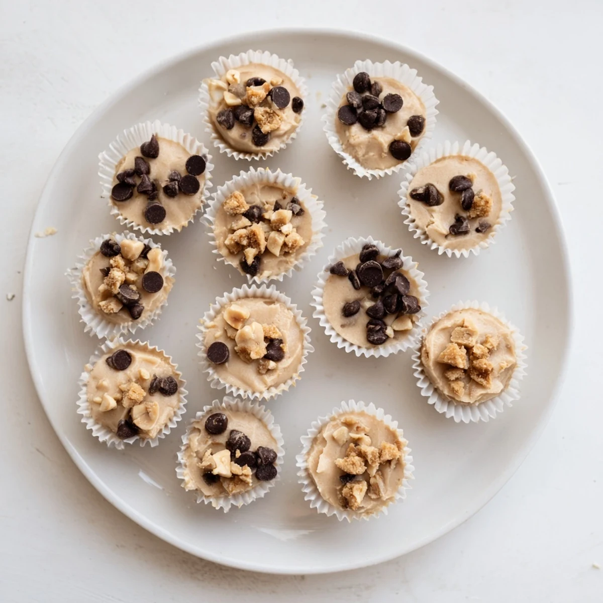Homemade frozen peanut butter Greek yogurt bites arranged in paper liners showing golden peanut butter swirls and glossy finish