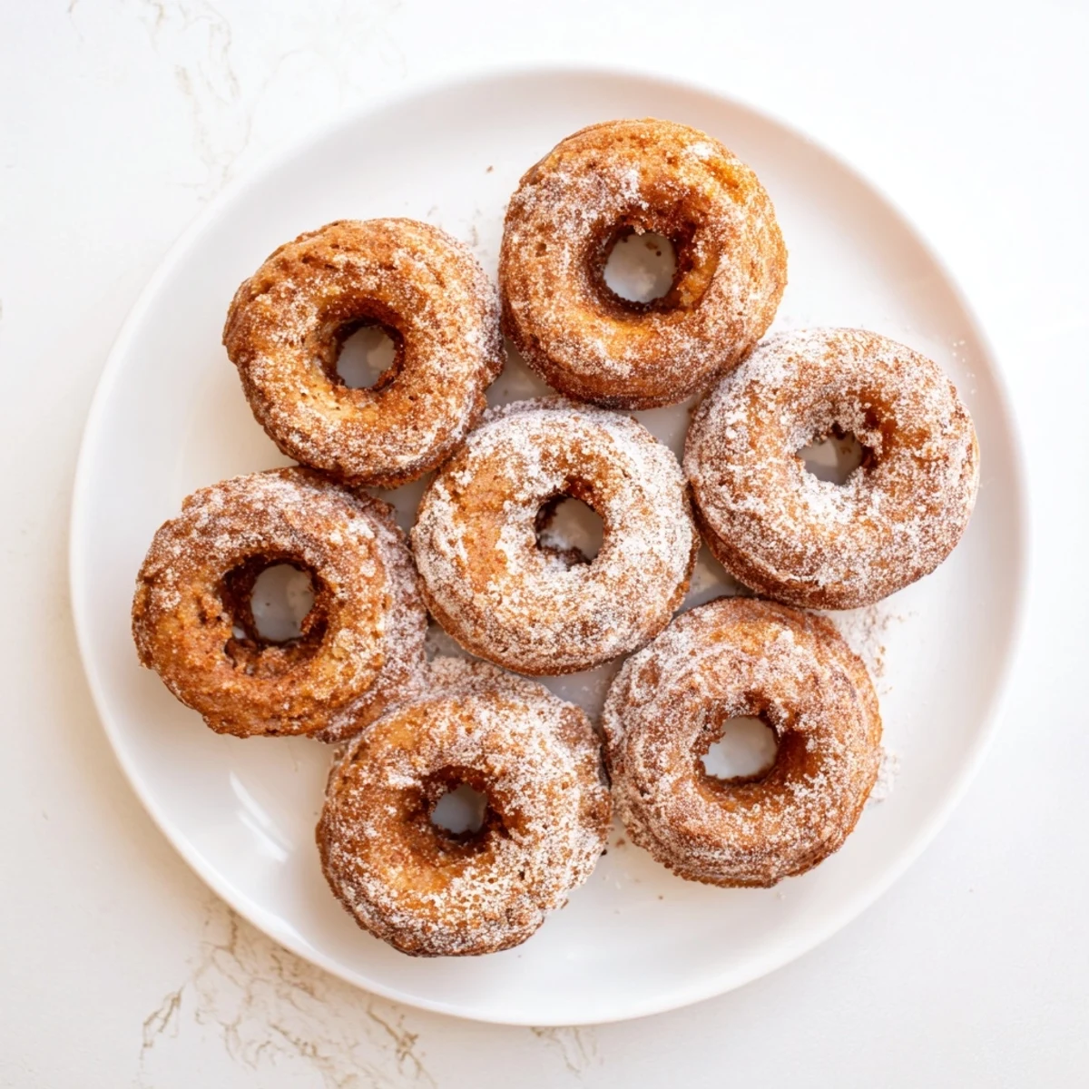 Freshly baked banana bread donuts with cinnamon sugar dusting on a wire rack