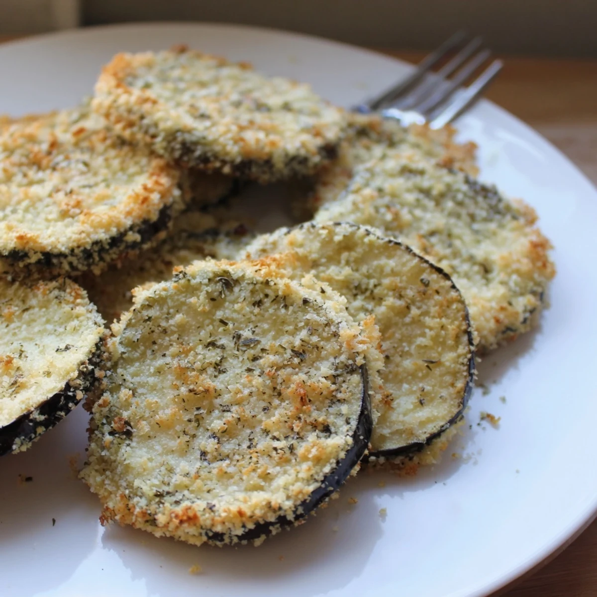 A platter of Crispy Baked Eggplant, warm herb aroma and Parmesan crust.
