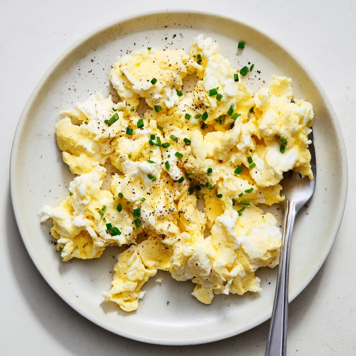 Cottage cheese scrambled eggs with chives, glossy and creamy, served on toast