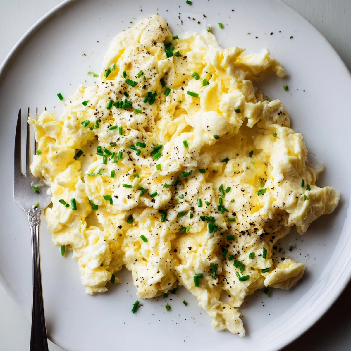 Cottage Cheese Scrambled Eggs with Chives plated alongside toasted sourdough