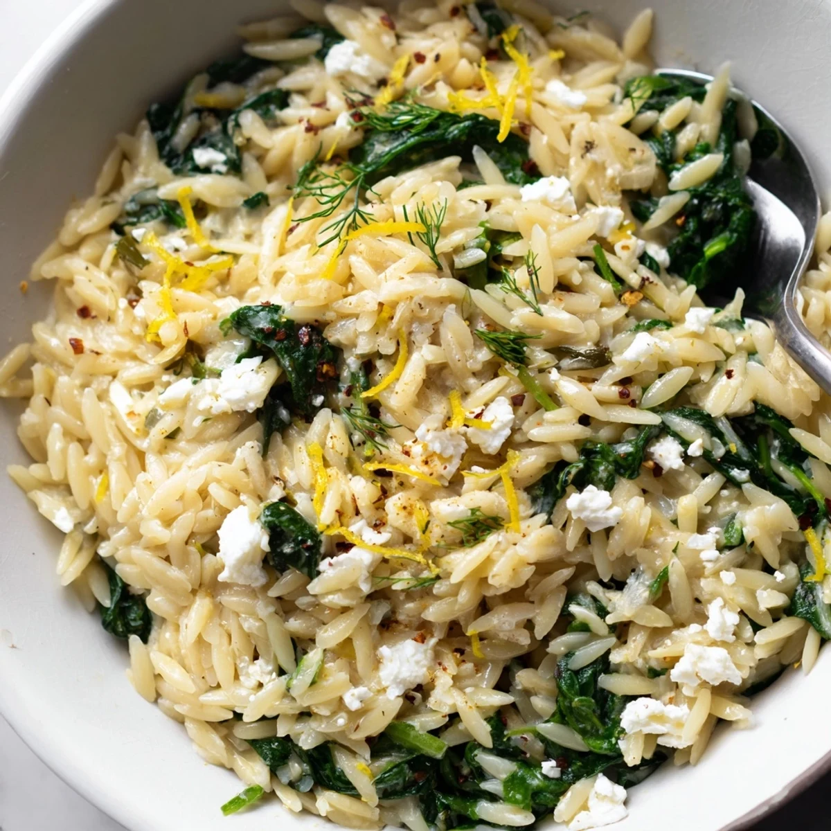 One Pan Lemon Orzo With Spinach Feta served steaming, topped with fresh dill.