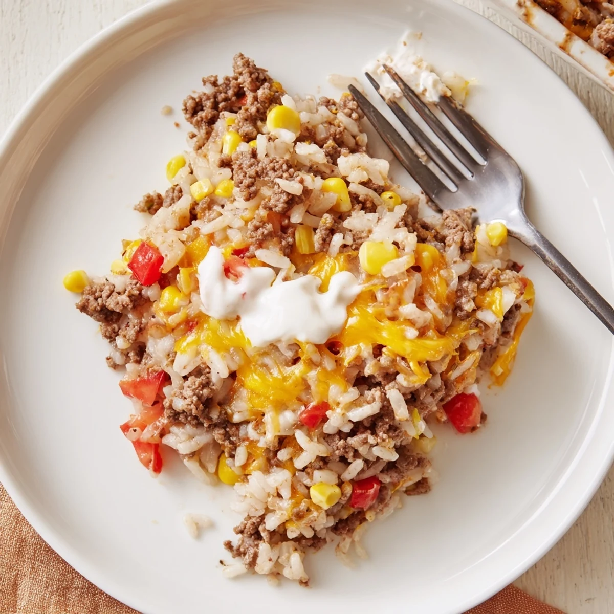 Spoonful of Cheesy Beef And Rice Delight Casserole with gooey melted cheddar