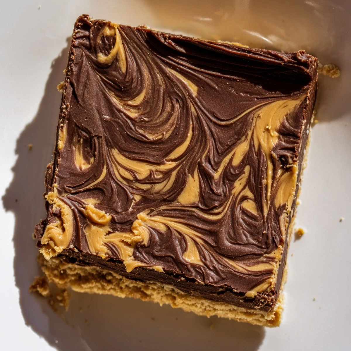 Golden peanut butter bars sliced into squares showcasing a smooth chocolate topping on a creamy no-bake crust