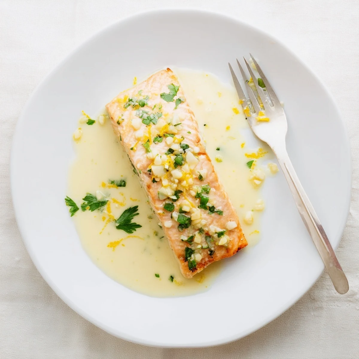 Golden pan-seared salmon fillets drizzled with creamy lemon garlic sauce and fresh parsley