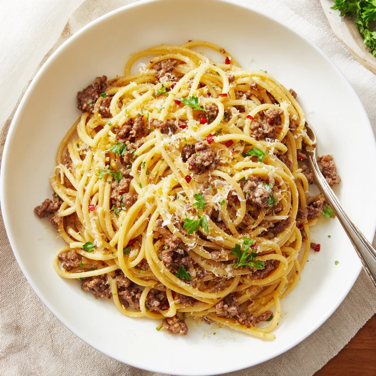 Creamy garlic butter pasta with ground beef topped with fresh parsley and Parmesan