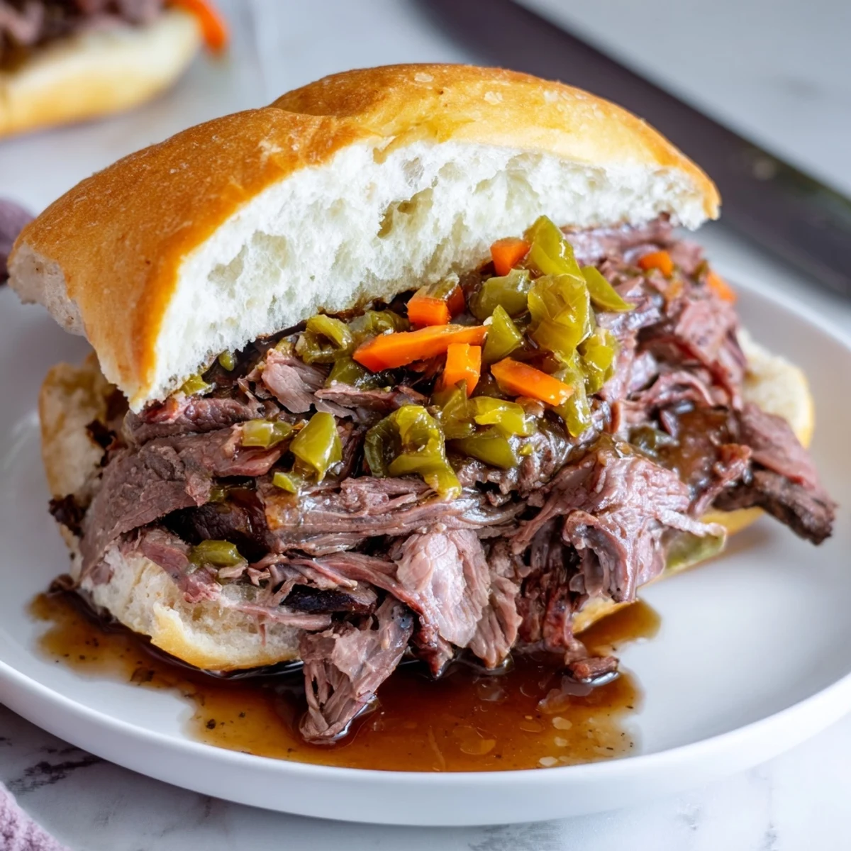 Juicy Chicago style Italian beef sandwich dripping with savory au jus and topped with colorful giardiniera